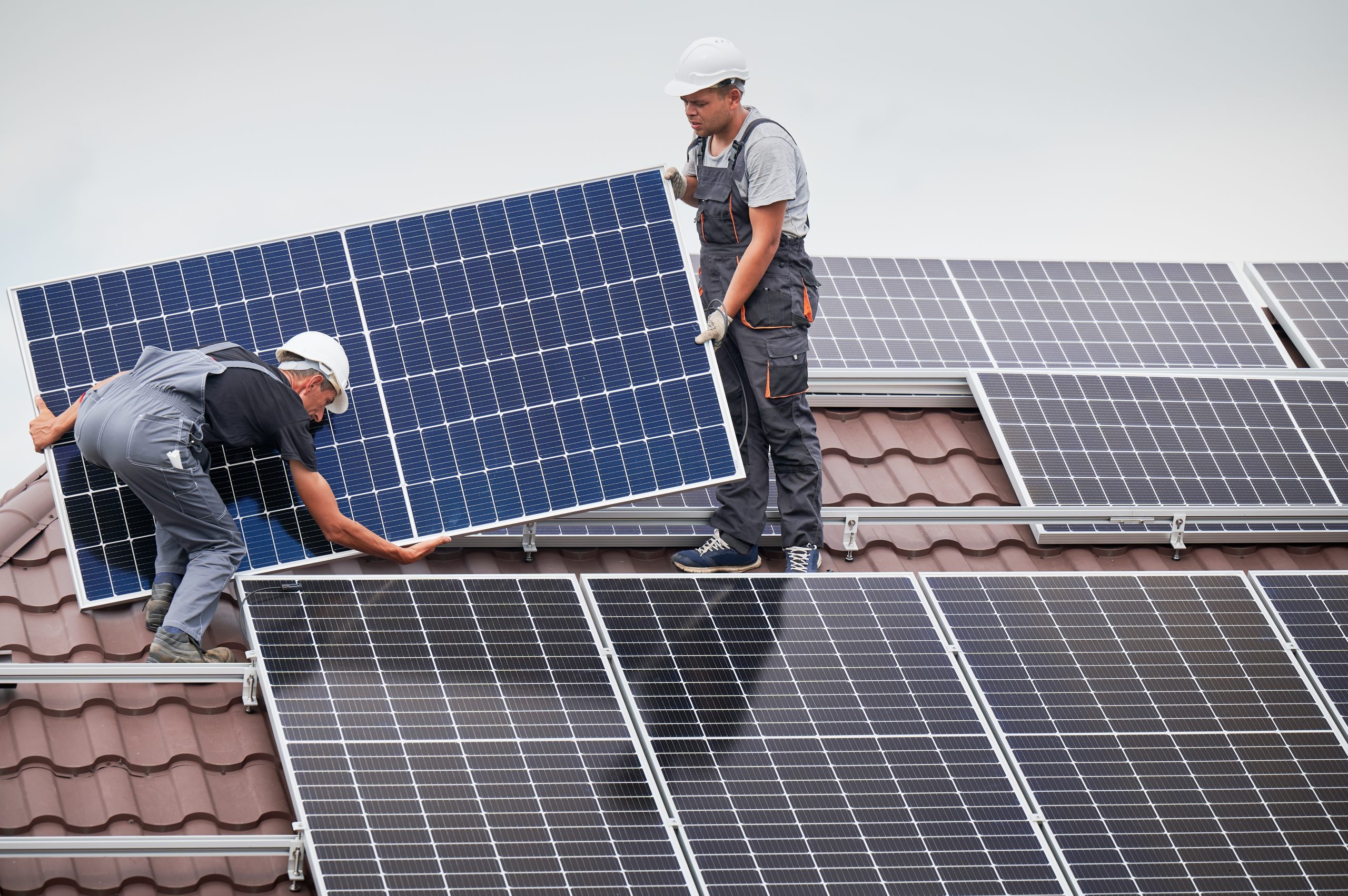 Expert solar panel installations work on residential home.
